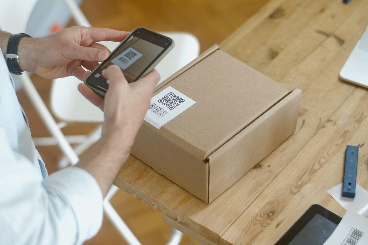 スマートフォンでQRコードを読み取る手元、eSIM設定のイメージ